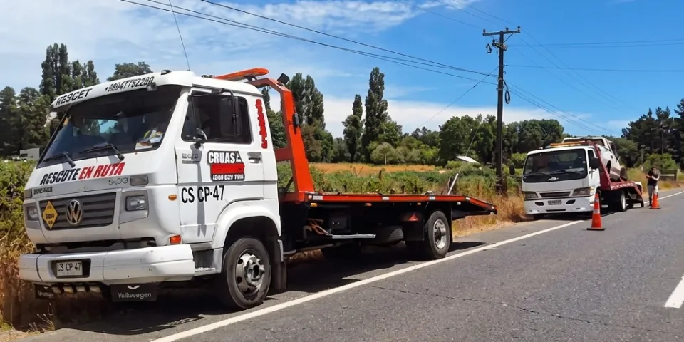 Dos grúas trabajando juntas en la carretera, a las afueras de Villarrica.