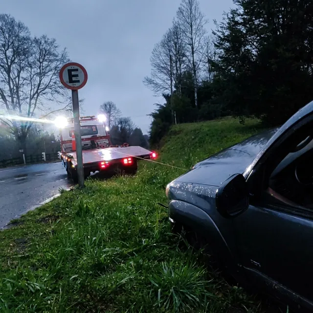 Grúa rescatando con cable una camioneta que se salió del camino entre Villarrica y Pucón.